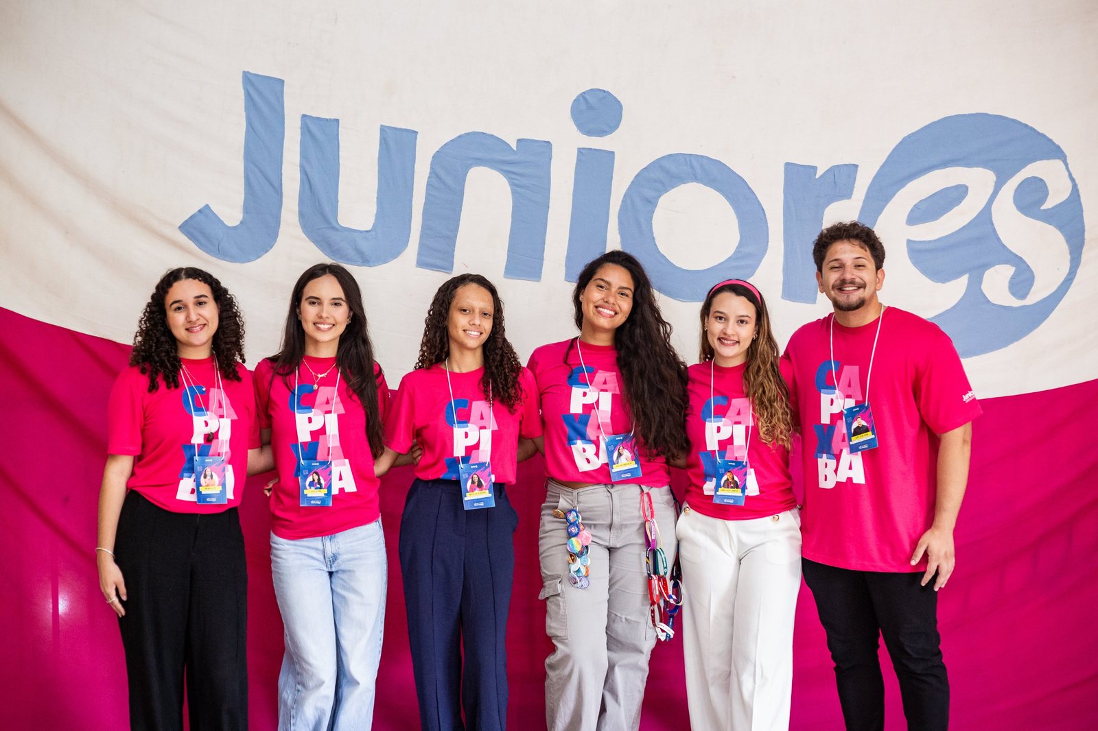 Seis empresários juniores lado a lado diante do bandeirão da Juniores